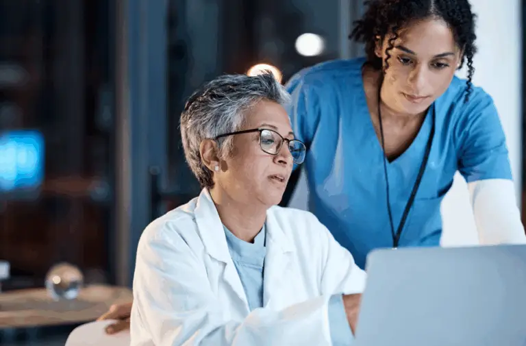 two health care providers look at a lap top