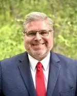 A professional headshot of a man