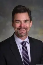 A professional headshot of a man