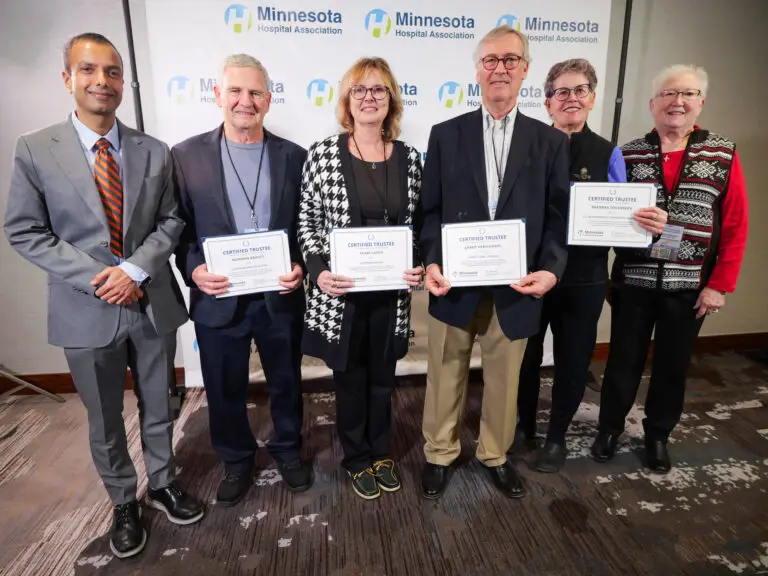 Newly certified trustees stand with their award certificates.