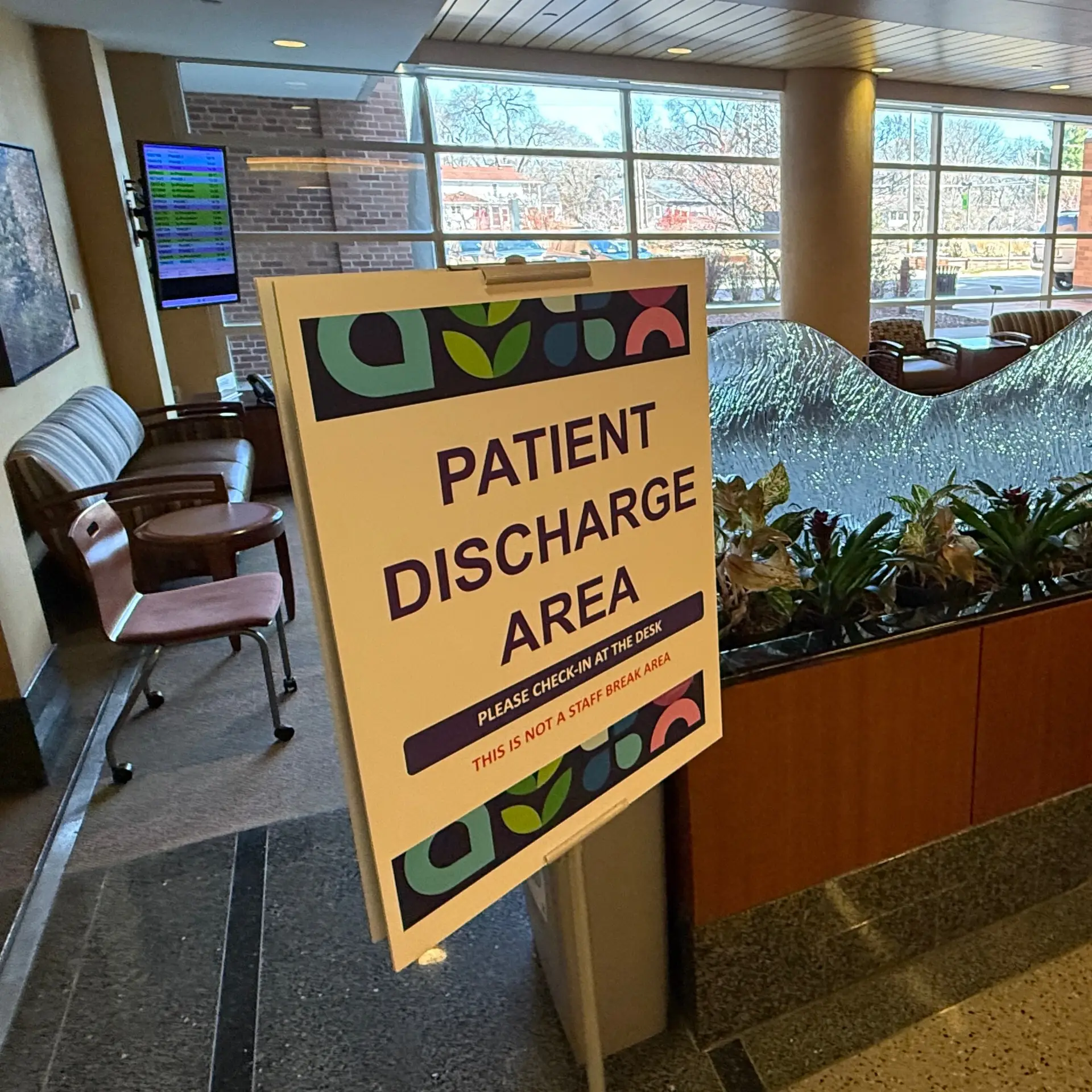 A sign located in a hospital designates the space as a patient discharge area.