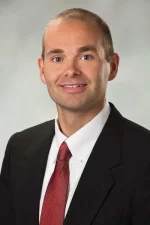 A professional headshot of a man