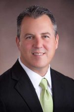 A professional headshot of a man